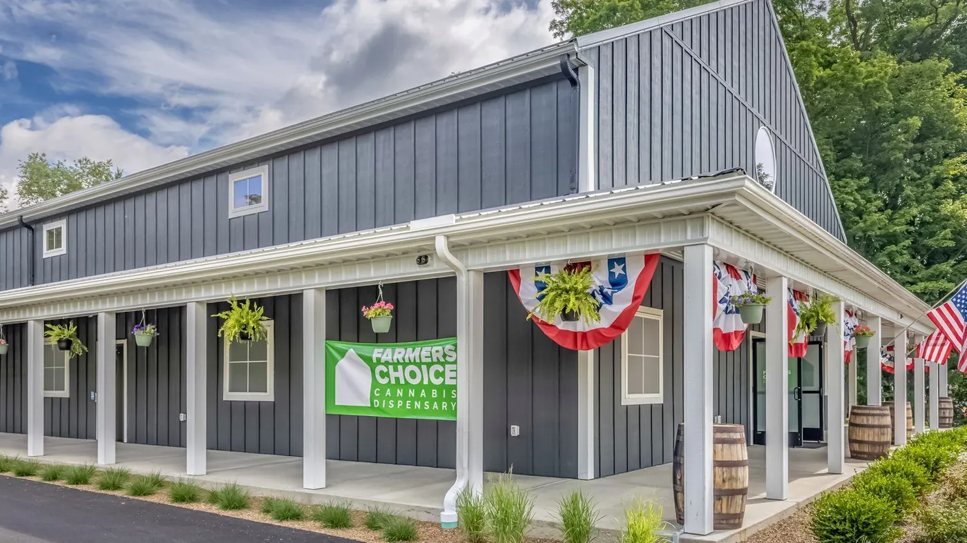 Farmers Choice dispensary building with patriotic bunting and green sign